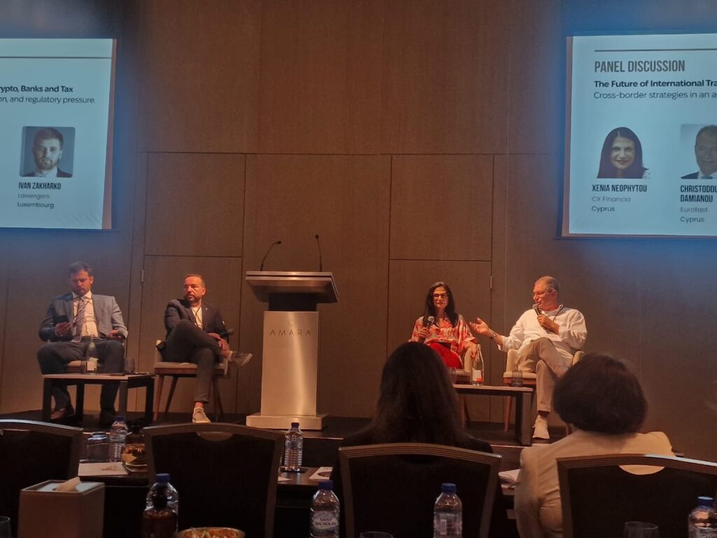  Xenia Neophytou and fellow panelist in active discussion on stage at Wealth & Relocation Forumm